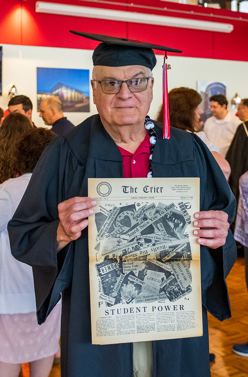 Sam McCune holding an issue of The Crier newspaper